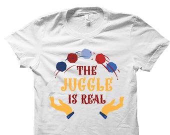 Könnte beinhalten: Weißes T-Shirt mit einer Grafik von Jonglierbällen und dem Text "The Juggle is Real".