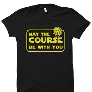 May include: Black t-shirt with a yellow graphic that says "May the Course Be With You" and a golf ball icon.