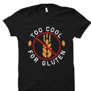 Puede incluir: Camiseta negra con un gr&aacute;fico blanco que dice "Too Cool For Gluten" con un c&iacute;rculo rojo y una espiga de trigo tachada.