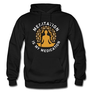May include: Black hooded sweatshirt with a white graphic design featuring a person meditating in a lotus position with a mandala behind them. The text reads "Meditation is my medication."