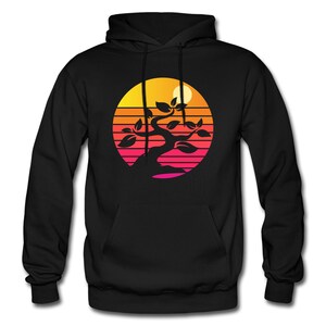 May include: Black hoodie with a graphic of a silhouette of a bonsai tree in front of a sunset with orange, yellow, pink, and red stripes.
