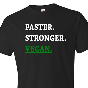 May include: Black t-shirt with the words "FASTER. STRONGER. VEGAN." printed in white and green. The shirt is a crew neck style and appears to be made of cotton.