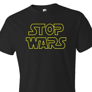 May include: Black t-shirt with a yellow outline of the text "STOP WARS" in a Star Wars-inspired font.