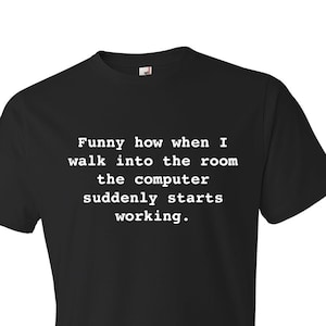 May include: Black t-shirt with white text that reads "Funny how when I walk into the room the computer suddenly starts working."