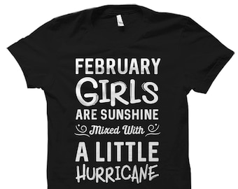 May include: Black t-shirt with white text that reads "FEBRUARY GIRLS ARE SUNSHINE Mixed With A LITTLE HURRICANE". The shirt has a crew neck and short sleeves.