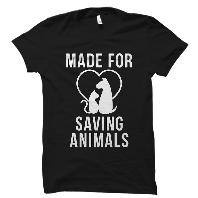 Pu&ograve; includere: Maglietta nera con testo bianco che recita "Made for Saving Animals". Sopra il testo &egrave; presente una silhouette bianca di un cane e un gatto all'interno di un cuore.