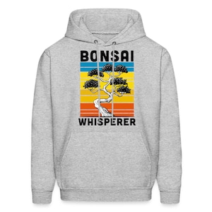 May include: A gray hoodie with a vintage-style graphic of a bonsai tree and the text "Bonsai Whisperer".