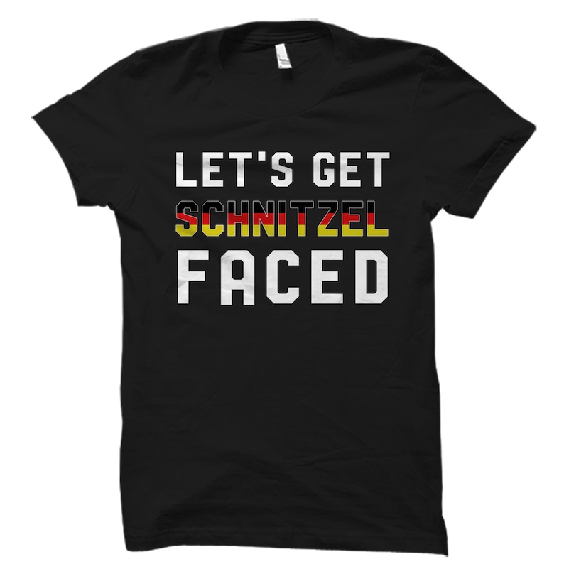 Puede incluir: Camiseta negra con texto blanco que dice "Let's Get Schnitzel Faced". La palabra "Schnitzel" est&aacute; en los colores de la bandera alemana.
