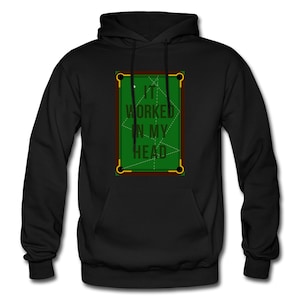 Puede incluir: Sudadera con capucha negra con un gráfico de mesa de billar verde y el texto "IT WORKED IN MY HEAD". El diseño de la mesa de billar tiene detalles marrones y dorados. La sudadera tiene un bolsillo delantero y una capucha con cordón.