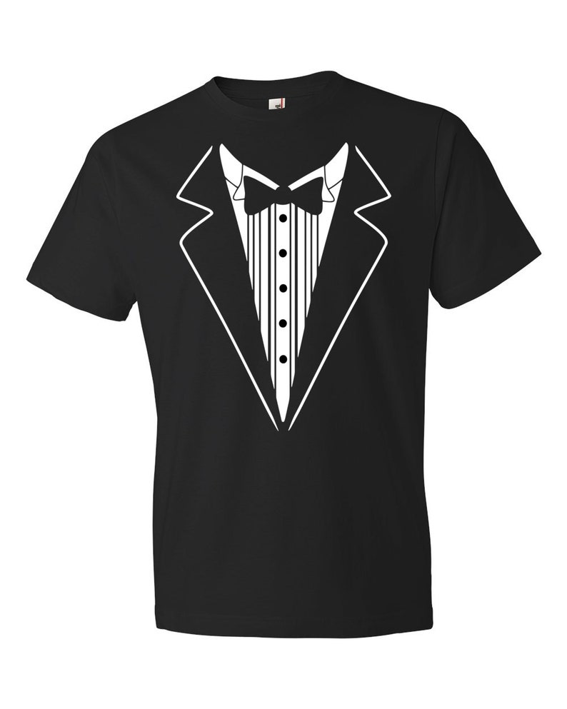 Puede incluir: Camiseta negra con un gr&aacute;fico de esmoquin blanco. El gr&aacute;fico presenta una pajarita, una solapa de chaqueta y una fila de botones.