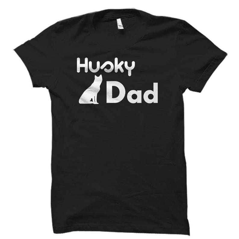 May include: Black t-shirt with white text that reads "Husky Dad" and a silhouette of a husky dog.
