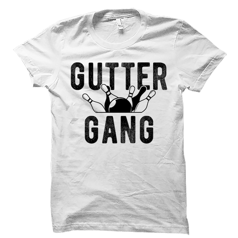 May include: White t-shirt with black text that reads "GUTTER GANG" and a graphic of bowling pins and a bowling ball.