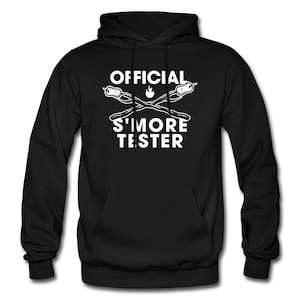 May include: Black hooded sweatshirt with white text that reads "OFFICIAL S'MORE TESTER" and a graphic of two crossed graham crackers with a marshmallow and a flame in between.