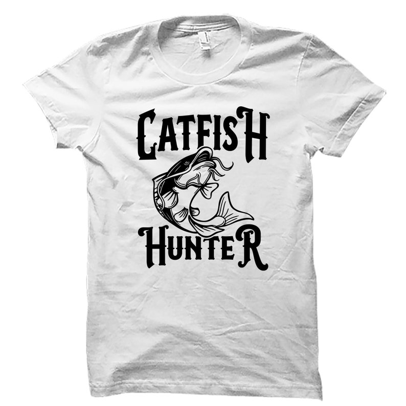 May include: White t-shirt with a black graphic of a catfish and the text "Catfish Hunter".