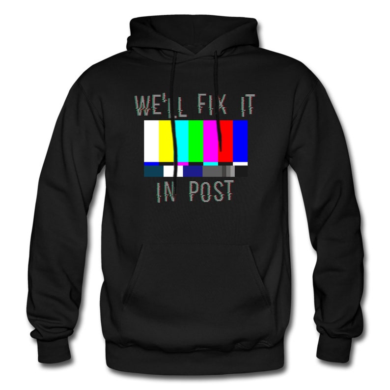 K&ouml;nnte beinhalten: Schwarzer Kapuzenpullover mit einem Grafikmuster eines Fernseh-Testbildes und dem Text "We'll fix it in post".