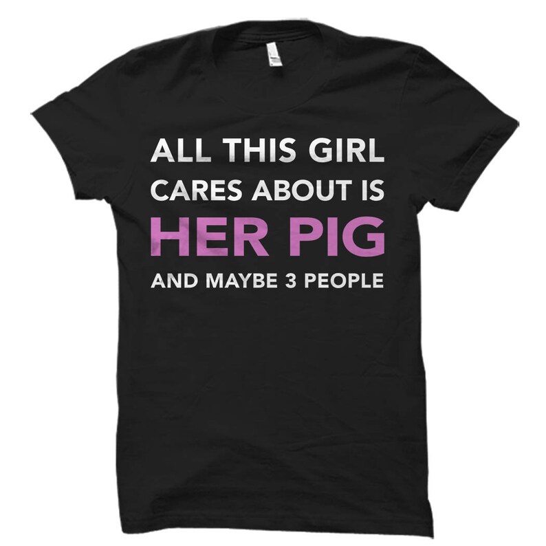 May include: Black t-shirt with white text that reads "All this girl cares about is her pig and maybe 3 people". The word "pig" is in pink.