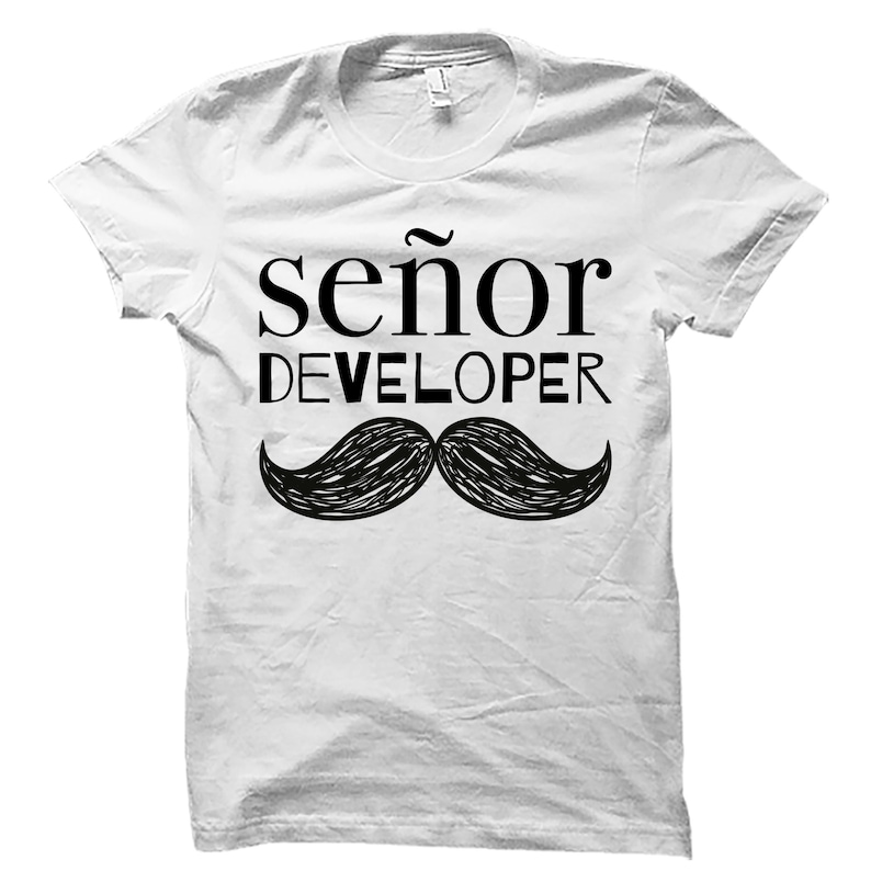 K&ouml;nnte beinhalten: Wei&szlig;es T-Shirt mit schwarzem Text "se&ntilde;or DEVELOPER" und einer schwarz-wei&szlig;en Mustasche-Grafik.