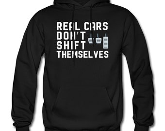 May include: Black hooded sweatshirt with white text that reads "Real Cars Don't Shift Themselves" and a graphic of a stick shift.
