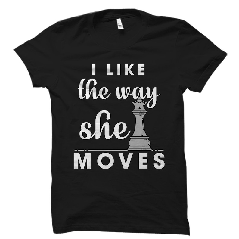 May include: Black t-shirt with the text "I like the way she moves" and a white chess queen graphic.