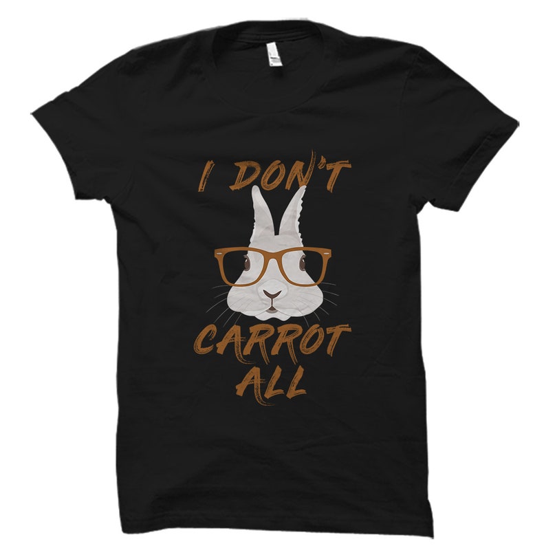 May include: Black t-shirt featuring a white rabbit wearing brown glasses and the text "I don't carrot all".