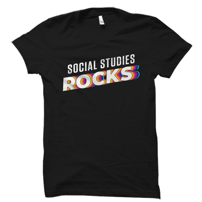 May include: Black t-shirt with the text "SOCIAL STUDIES ROCKS" in white with rainbow colored outlines.