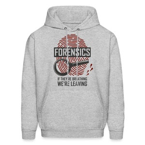 May include: A gray hoodie with a red fingerprint design and the text "FORENSICS" in black. Below the fingerprint is a magnifying glass and the text "IF THEY'RE BREATHING WE'RE LEAVING".
