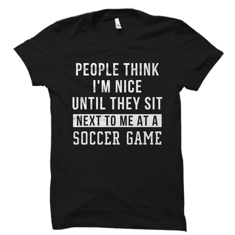May include: Black t-shirt with white text that reads "People think I'm nice until they sit next to me at a soccer game."