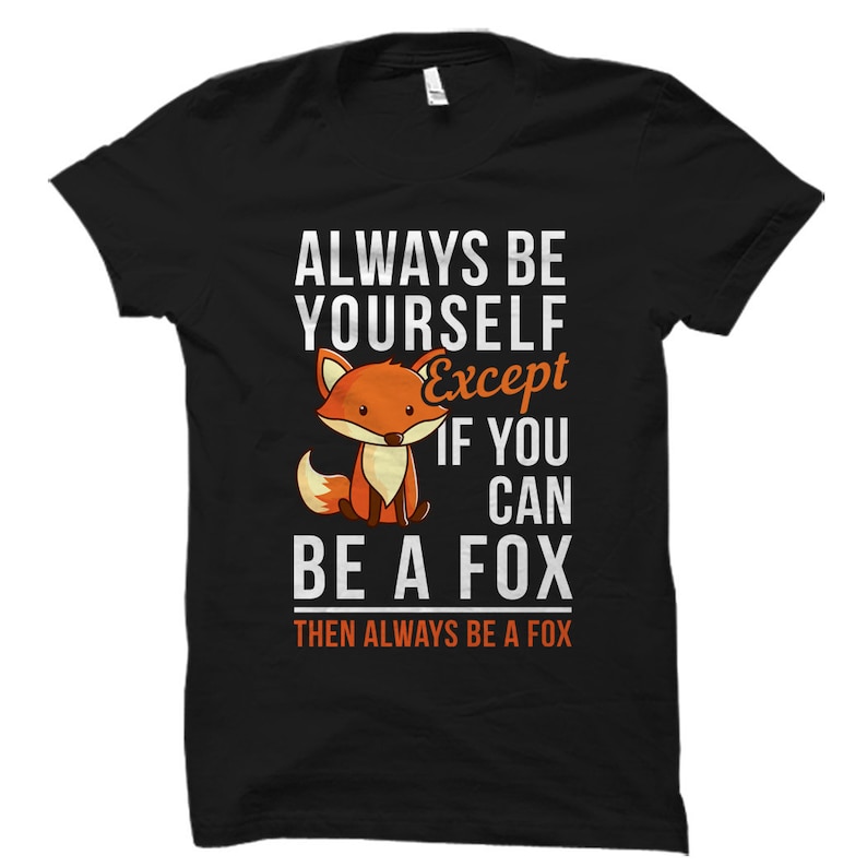 Puede incluir: Camiseta negra con un gr&aacute;fico blanco que dice "Siempre s&eacute; t&uacute; mismo, excepto si puedes ser un zorro, entonces siempre s&eacute; un zorro". El gr&aacute;fico tambi&eacute;n incluye un zorro de dibujos animados.