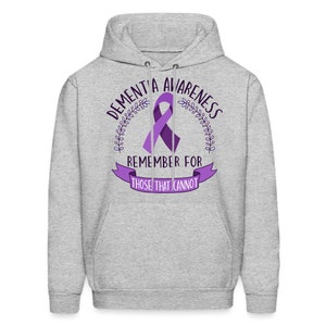 May include: A gray hooded sweatshirt with the text "Dementia Awareness" and a purple ribbon. The text "Remember for those that cannot" is below the ribbon.