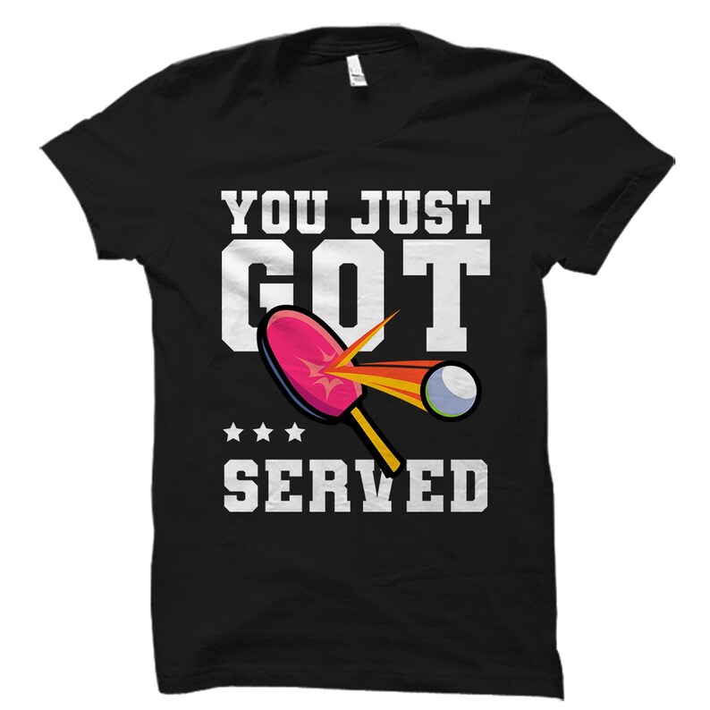 Puede incluir: Camiseta negra con texto blanco que dice "You Just Got Served" y un gr&aacute;fico de una pala de ping pong golpeando una pelota.
