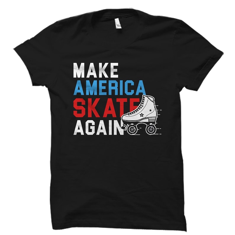 Op de afbeelding: Zwart T-shirt met een witte, rode en blauwe afbeelding met de tekst "Make America Skate Again" met een tekening van een rolstoel.