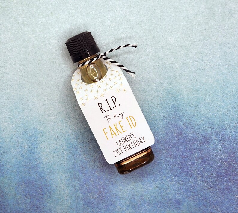 Pu&ograve; includere: Un'etichetta bianca con lettere dorate legata a una piccola bottiglia di liquore. L'etichetta recita "R.I.P. to my FAKE ID Lauren's 21st Birthday".