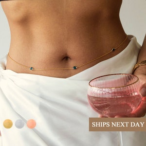 a gold belly chain with birth month stones attached to it in three colors of gold, rose gold, silver.