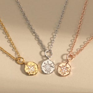 May include: Three gold, silver, and rose gold necklaces with a star-shaped pendant. Each pendant features a star with a small diamond in the center.