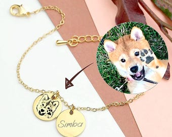 May include: Gold chain bracelet with two charms. One charm features a black and white photo of a dog's face. The other charm is engraved with the name "Simba".
