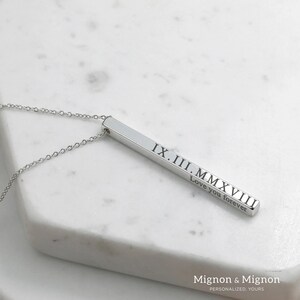 May include: Silver bar necklace with the date IX.II.MMXVIII and the text "Love you forever" engraved on it.