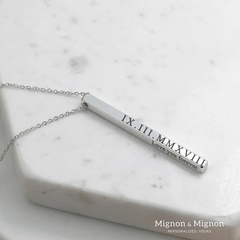 May include: Silver bar necklace with the date IX.II.MMXVIII and the text "Love you forever" engraved on it.