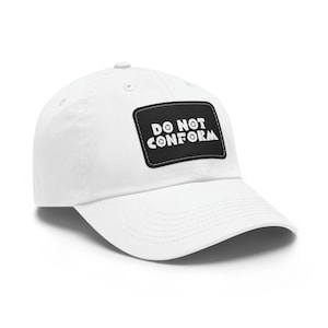 May include: White baseball cap with a curved peak. A black rectangular patch on the front displays the white text "DO NOT CONFORM". The cap is made of a soft material and has a button on top.