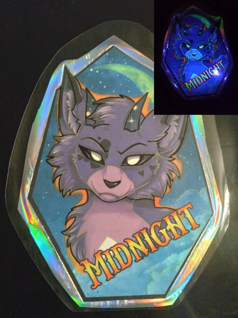 May include: A holographic sticker featuring a stylized purple wolf with horns and a stern expression. The sticker has a blue and starry background with the word "MIDNIGHT" in orange. A smaller, glowing version of the sticker is also shown.