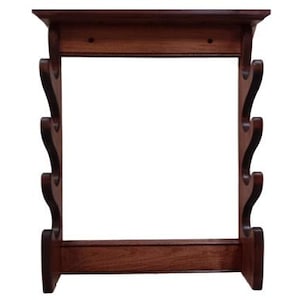 May include: A dark brown wooden wall-mounted gun rack. The rack features a top shelf, a base, and decorative curved supports. The wood has a rich, warm tone, and the design is traditional. The rack is designed to hold multiple firearms.