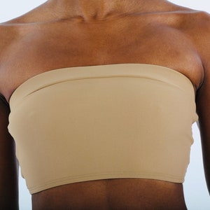 Peut inclure: Un haut bandeau sans bretelles de couleur chair, en tissu doux et extensible. Le haut est sans couture et offre un ajustement confortable et lisse.