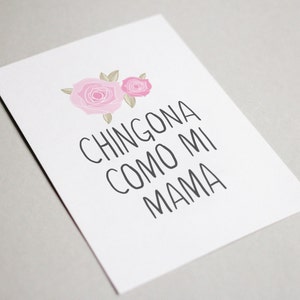 Op de afbeelding: Een witte kaart met twee roze rozen en de tekst "CHINGONA COMO MI MAMA" in zwart.
