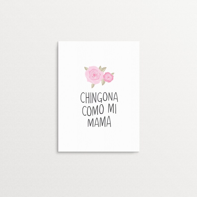 Op de afbeelding: Een witte kaart met twee roze rozen en de tekst "CHINGONA COMO MI MAMA" in zwart.