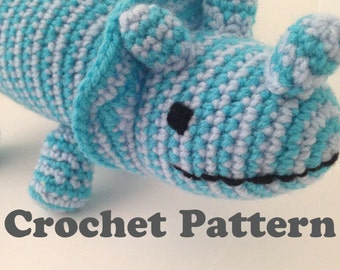 May include: Crocheted blue and white dinosaur toy with black eyes and a black mouth. Crochet Pattern.