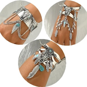 May include: Three silver bracelets with turquoise accents and a skull design. The bracelets are made of metal and have a bohemian style.