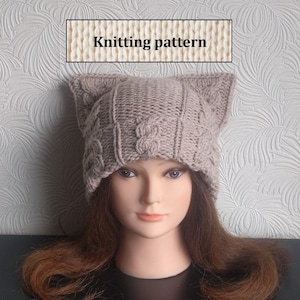 May include: A beige knitted hat with cat ears. The hat features a cable knit pattern.