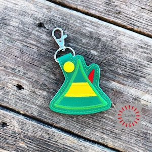 May include: A green, yellow and red felt elf hat keyring with a silver key ring. The hat has a yellow circle in the centre.