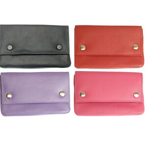 May include: Four leather wallets in different colours: black, red, purple, and pink. Each wallet has two gold snaps and a fold-over flap.