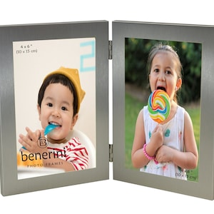 Könnte beinhalten: Silberner Doppel-Bilderrahmen mit zwei Öffnungen von 10 x 15 cm. Der Rahmen ist geschlossen und zeigt zwei Fotos von Kindern. Das linke Foto zeigt ein Kind mit einem gelben Hut und einem rot-weiß gestreiften Shirt. Das rechte Foto zeigt ein Kind, das einen bunten Lolli hält.