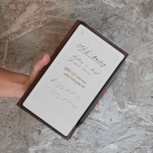 May include: A brown leather tablet case with a digital notepad displaying handwritten notes. The notes include the date, "17/6/6-Monday", and the words "BRING Voice RECORD". A black stylus is attached to the side of the tablet.